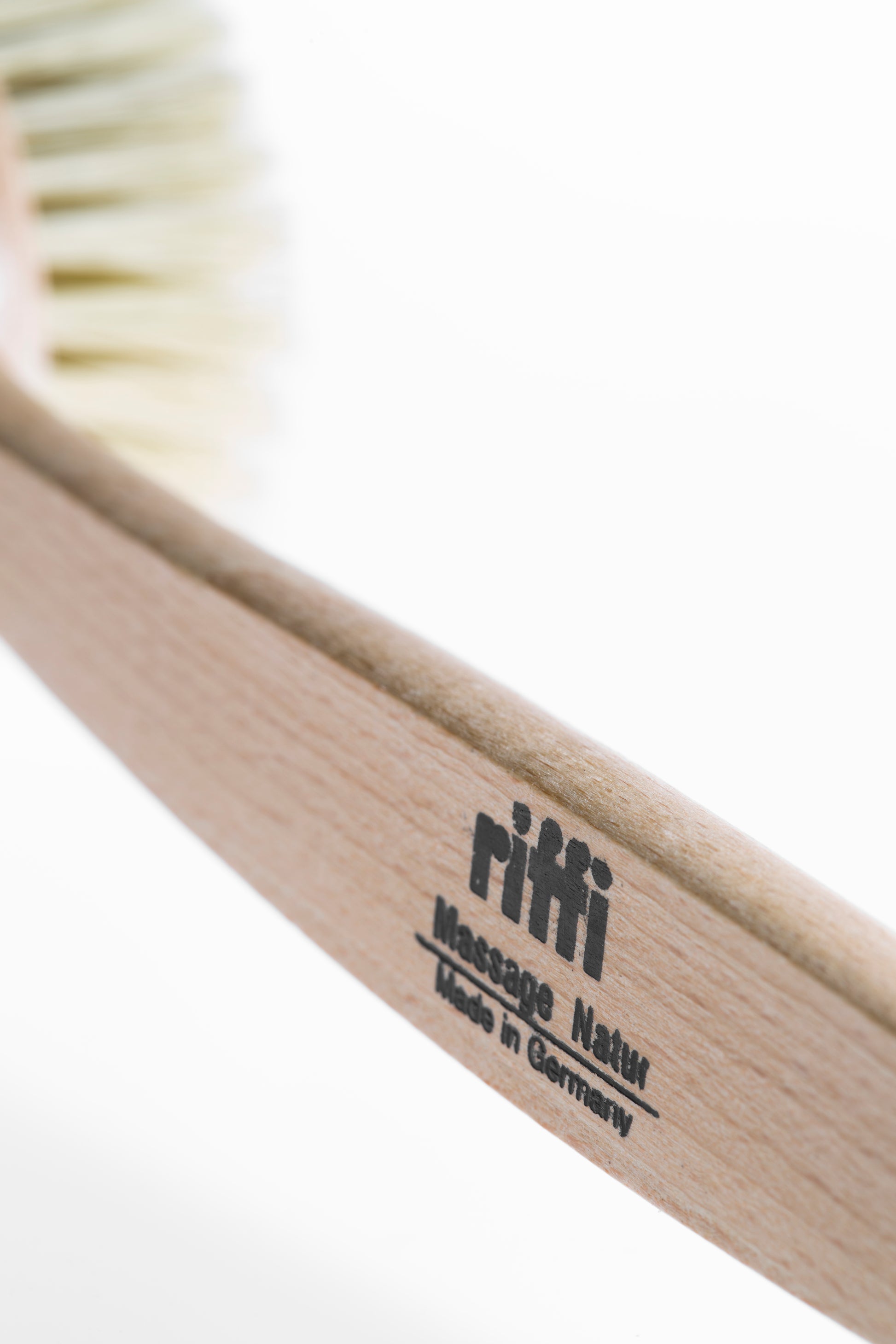 Detailaufnahme des Holzstiels der riffi Badebürste Natur mit Branding „Massage Natur – Made in Germany“ auf geöltem Buchenholz.