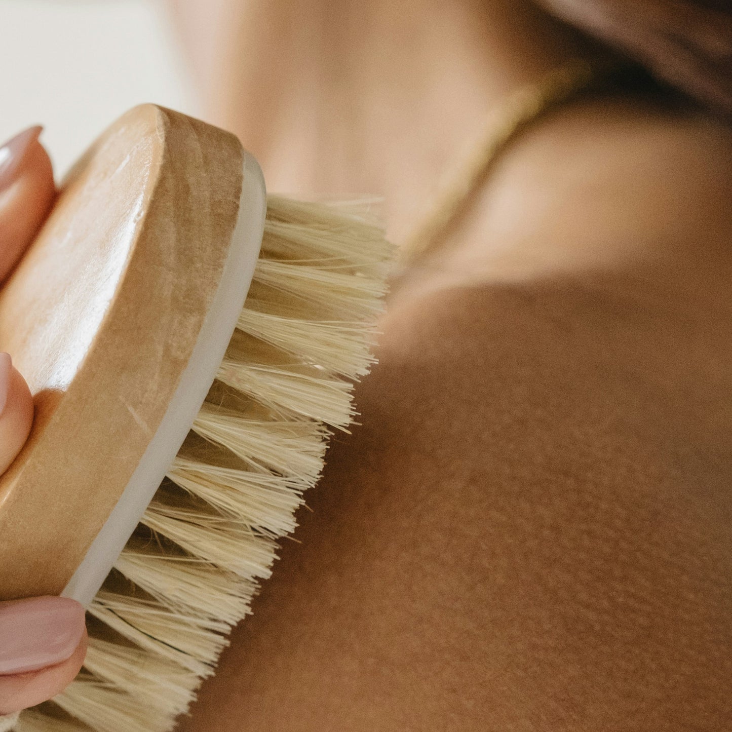 Anwendung einer Riffi Massagebürste mit Naturborsten zur Trockenmassage, fördert die Hautdurchblutung und unterstützt eine glatte, gepflegte Haut.